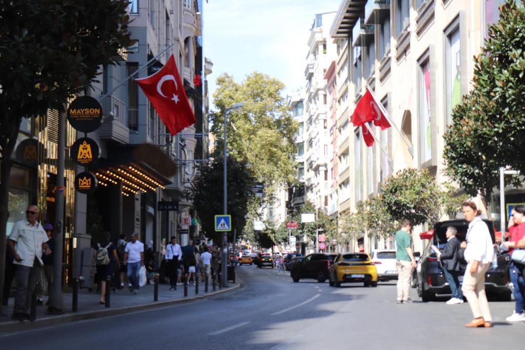 伊斯坦布尔Mas Suites Nisantasi的一条繁忙的城市街道,人们在街上散步,悬挂着旗帜