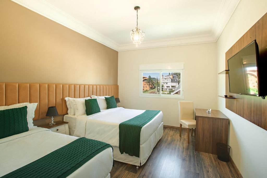 坎波斯杜若尔当Altitude Lodge Hotel的酒店客房设有两张床和电视。