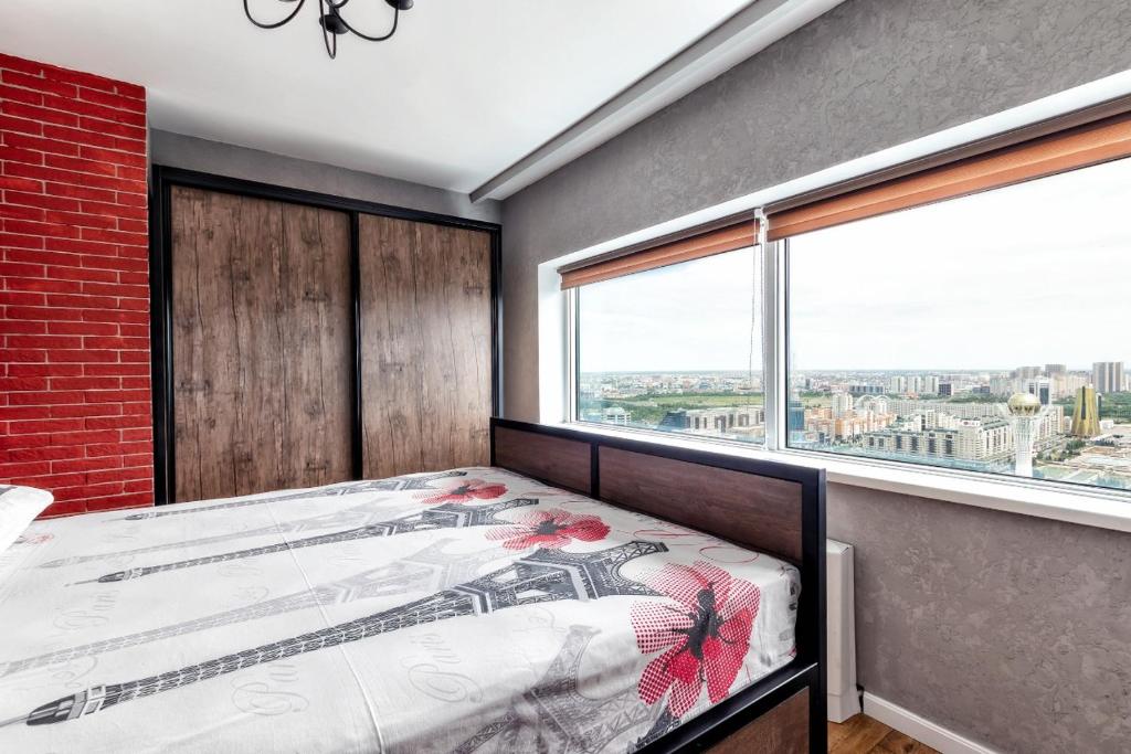 阿斯塔纳Apartment Severnoye Siyaniye 37的一间卧室设有一张床和一个大窗户