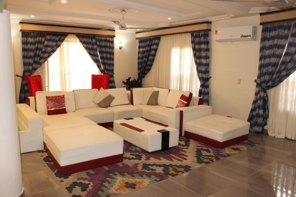 阿克拉FREDA'S COURT的客厅配有白色沙发和地毯。