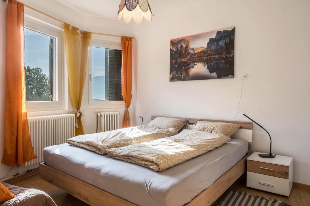 博尔扎诺Ferienhaus Weingut Plonerhof的一间卧室设有一张床和两个窗户。