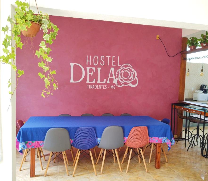 蒂拉登特斯Hostel Dela的一张桌子,椅子和读着旅馆花花花花的标志