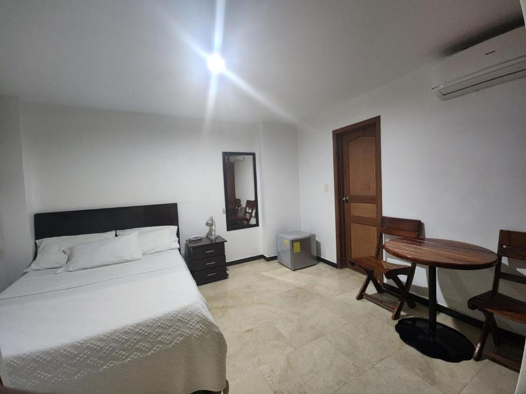 卡利Hotel Ciudad Capri的一间卧室配有一张床、一张桌子和一面镜子