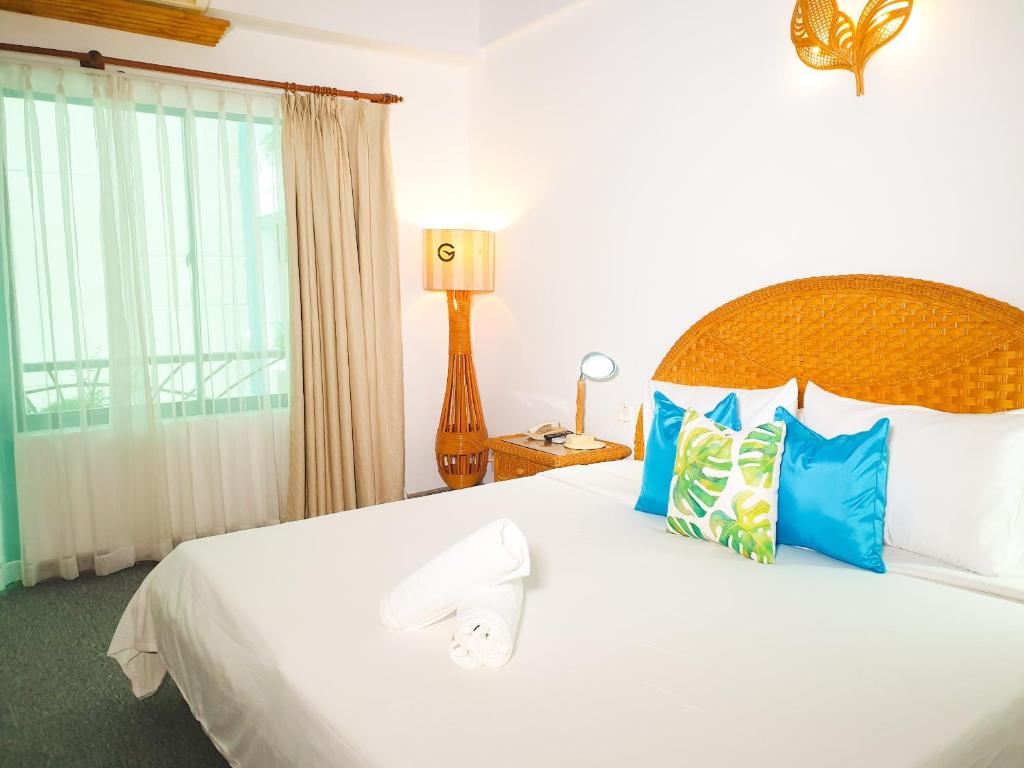 芽庄GREEN ANT NHA TRANG的卧室配有带蓝色枕头的大型白色床