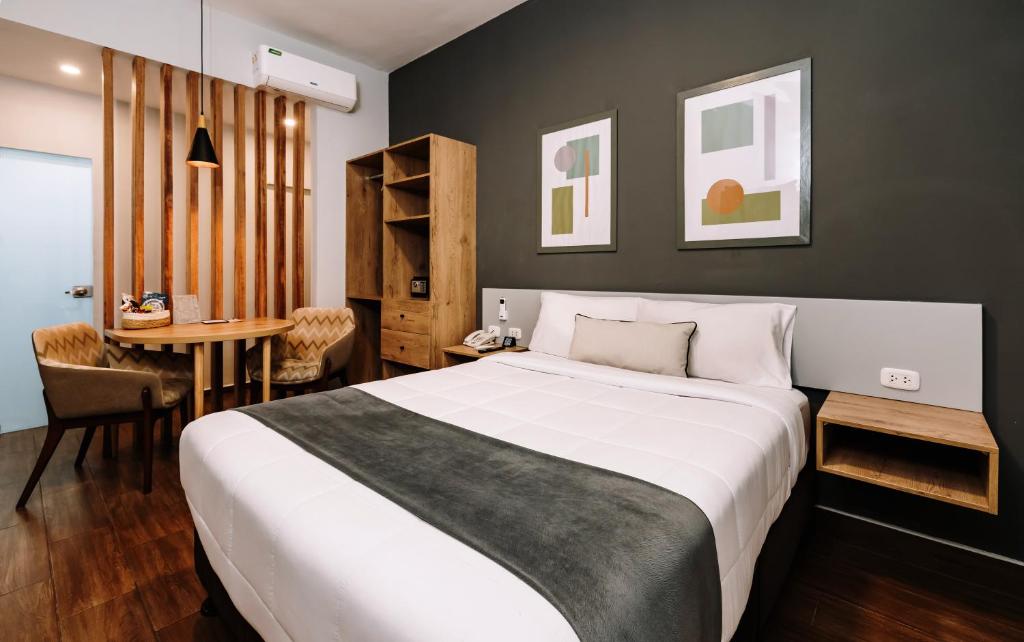利马TARATA BOUTIQUE HOTEL的卧室配有一张白色的大床和一张桌子