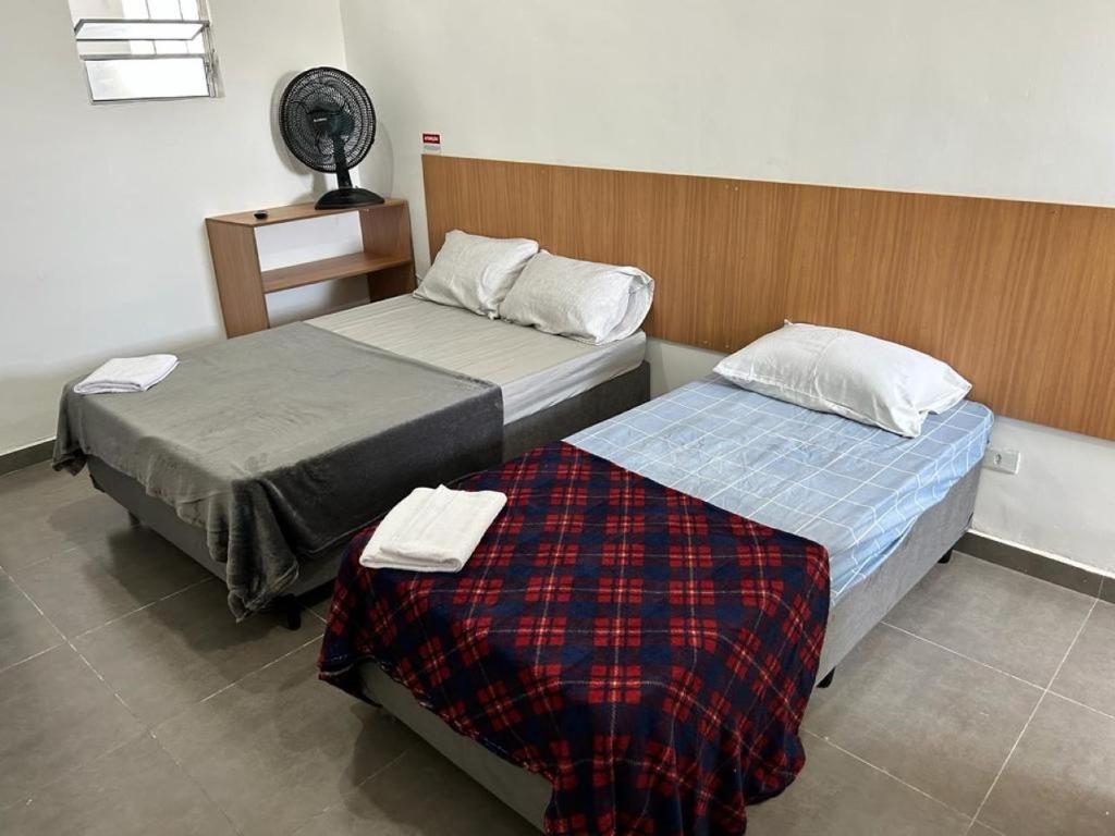 圣保罗Studio mobiliado na Vila Guilherme - São Paulo/SP的客房设有两张床和风扇。