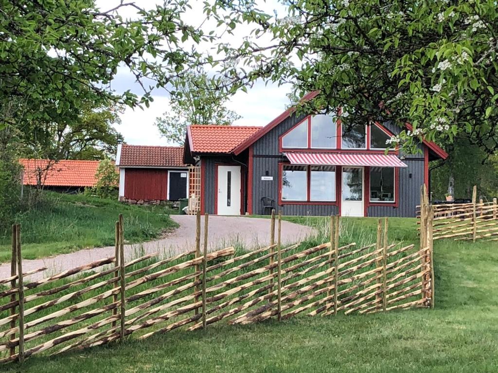 KalvJoarsbo, Stuga 3, Klinten的红黑房子,设有木栅栏