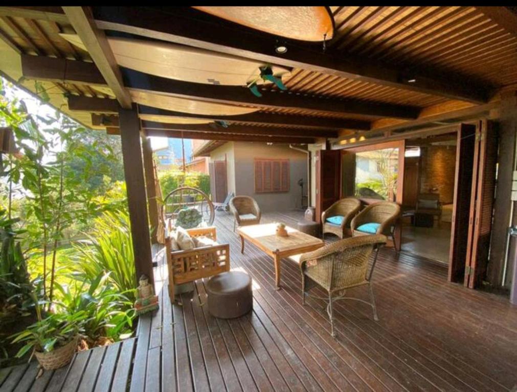 加罗帕巴Aconchegante e charmosa casa的木制甲板上配有桌椅