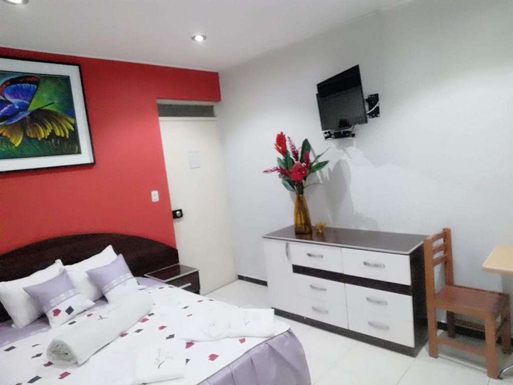 马尔多纳多港Hotel Botón de Oro的一间卧室设有一张床和红色的墙壁