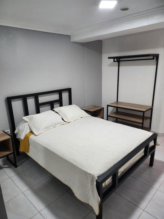 巴拿马城西班牙大道酒店的一张床位,房间设有两个床头柜和一张四柱床