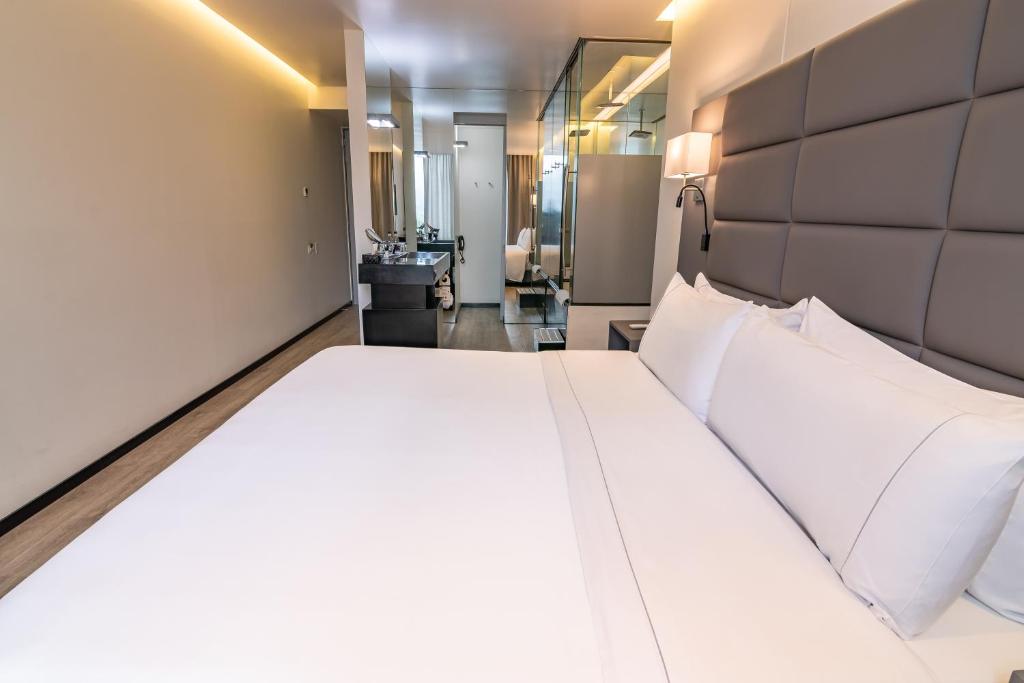 波哥大收集93GHL酒店的卧室配有一张白色大床