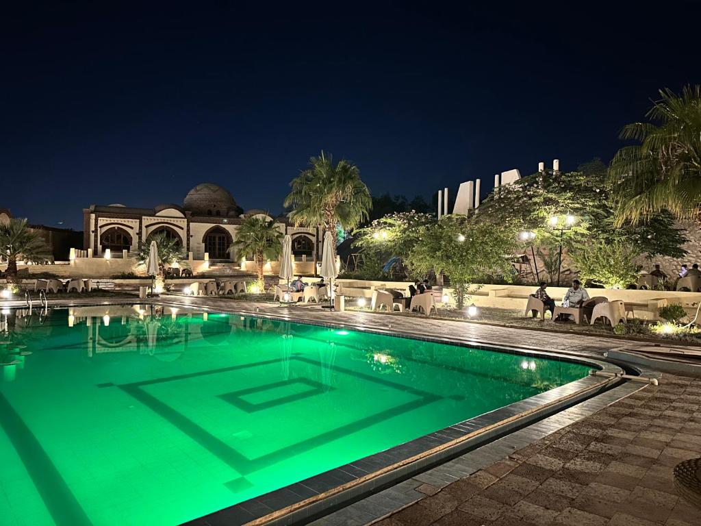 卢克索Elphardous Oasis Hotel的游泳池,晚上有绿色的灯光