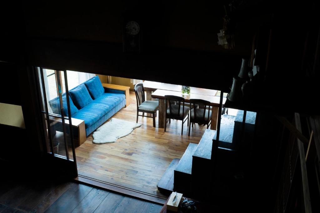 十日町古民家宿Tani House Itaya -セルフチェックイン的客厅配有蓝色的沙发和桌子