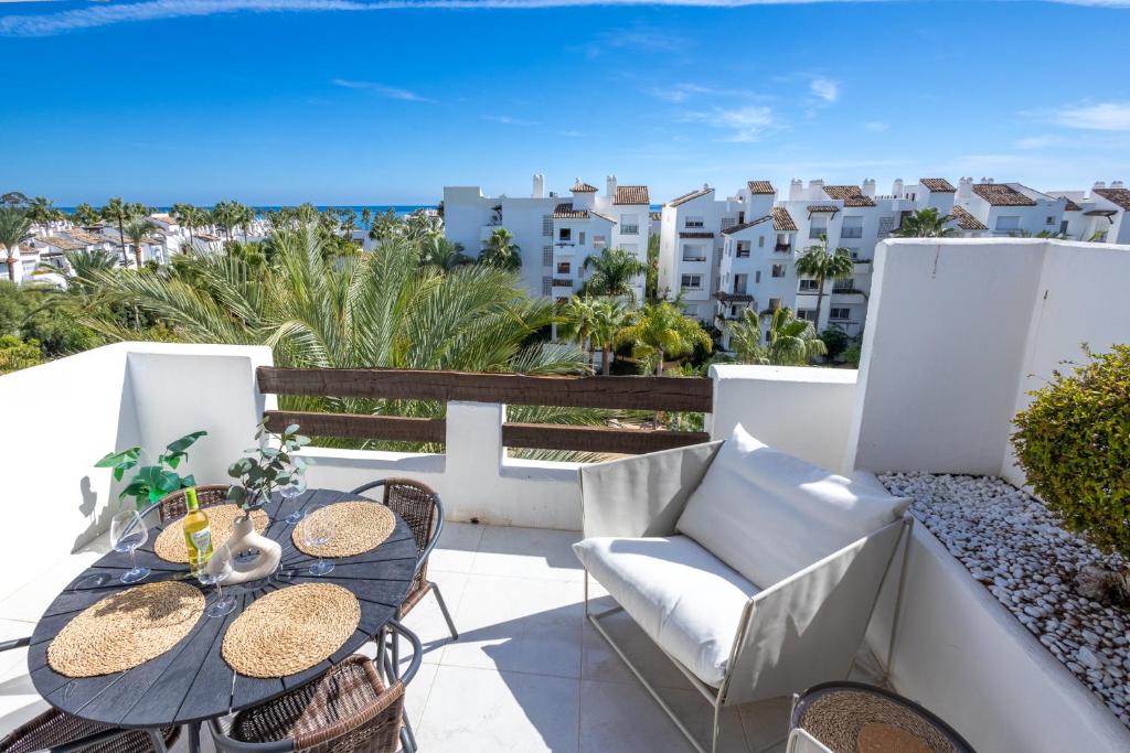 EsteponaTop floor spacious apartment with sea views in Costalita的阳台配有桌椅,享有海景。