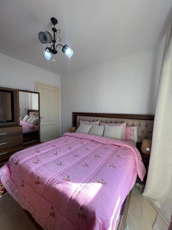 MadinatyGrand Madinaty 2BR Home-EID Mubarak的卧室配有粉红色的床和镜子