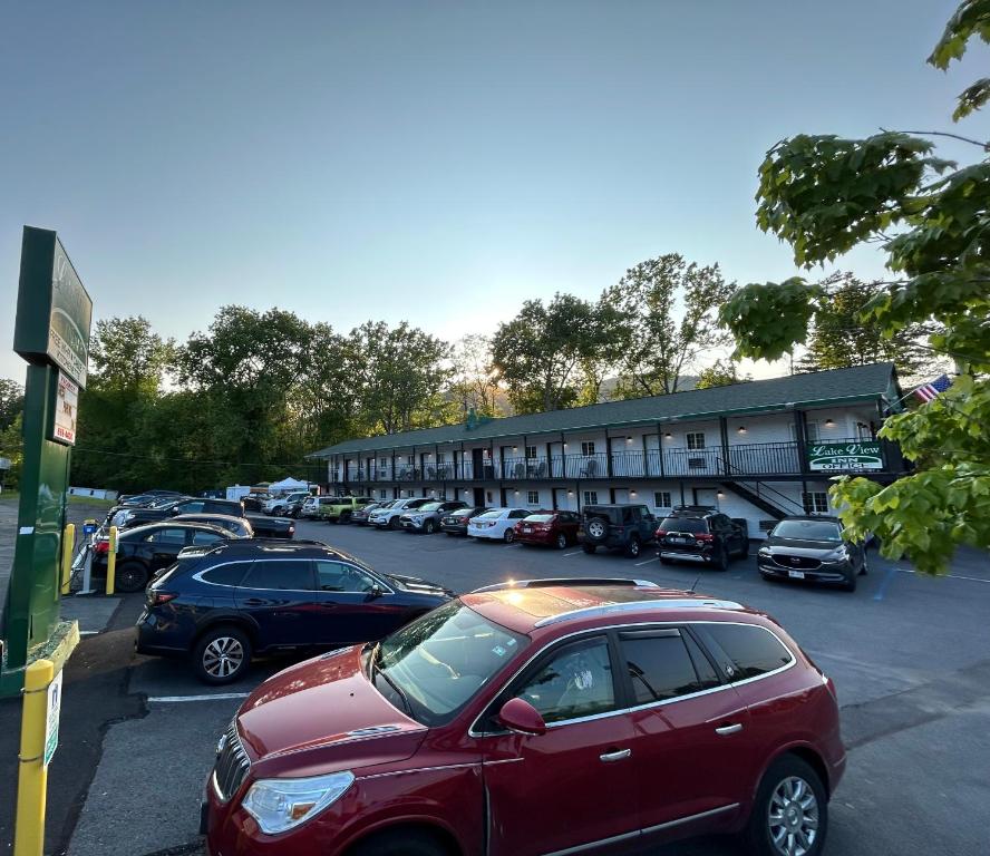 乔治湖乔治湖景汽车旅馆的停在大楼旁边的停车场的红色汽车