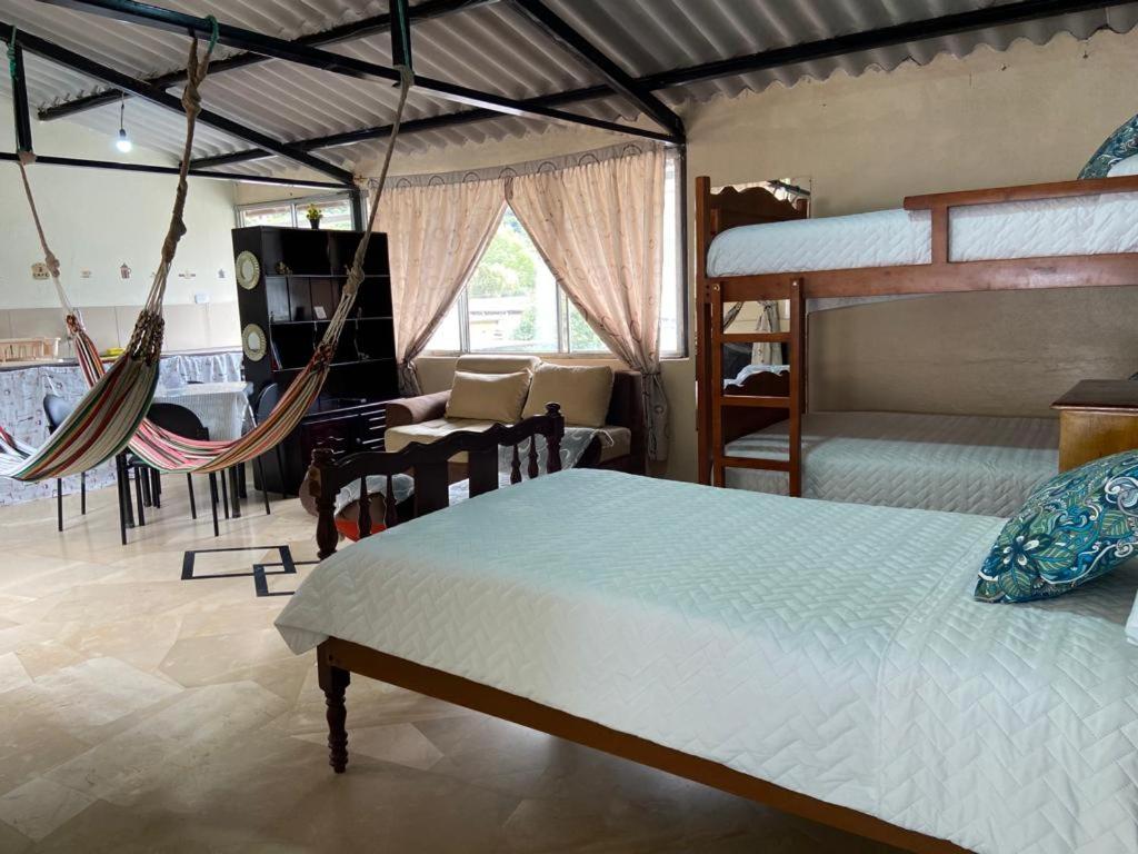 巴尼奥斯APARTAMENTO ESTUDIO - COMPLETO Y MUY BIEN UBICADO的一间卧室设有两张床和吊床
