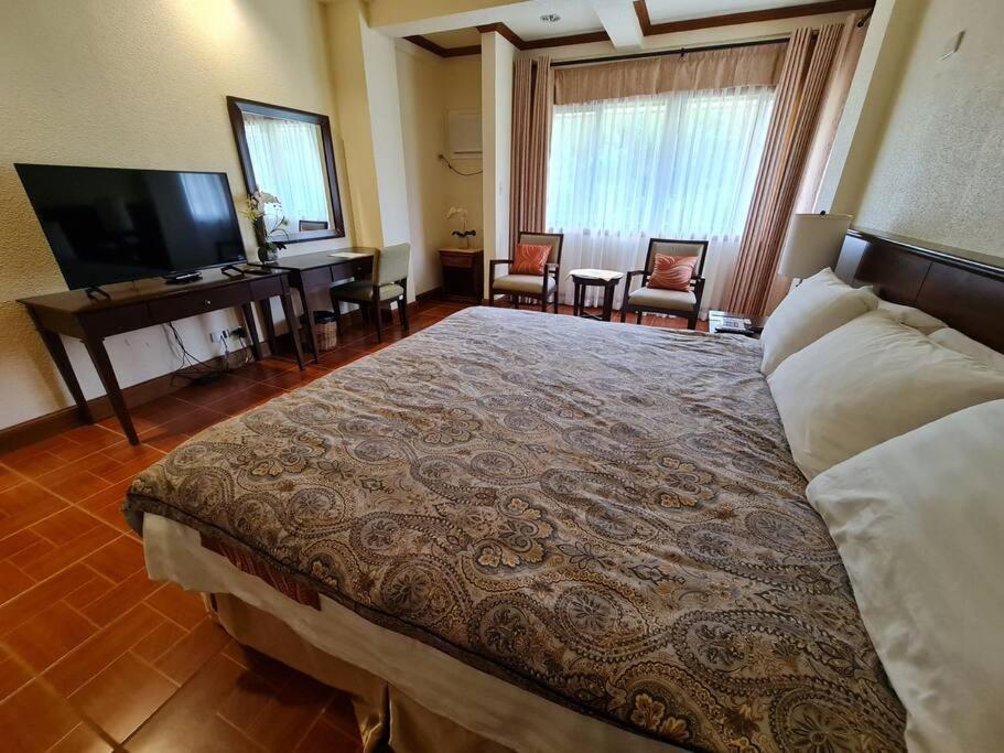 利帕Luxury 1 BR Suite Malarayat Lipa的一间酒店客房,配有一张大床和一台平面电视