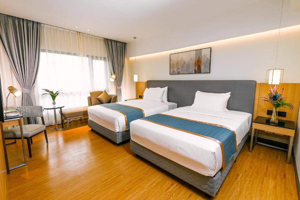 马尼拉Ardenhills Suites的酒店客房配有两张床和一张书桌