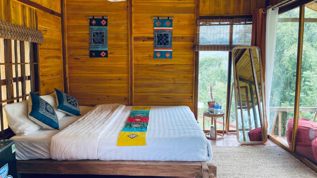 Làng CacDu Gia Panorama的卧室配有木墙内的一张床