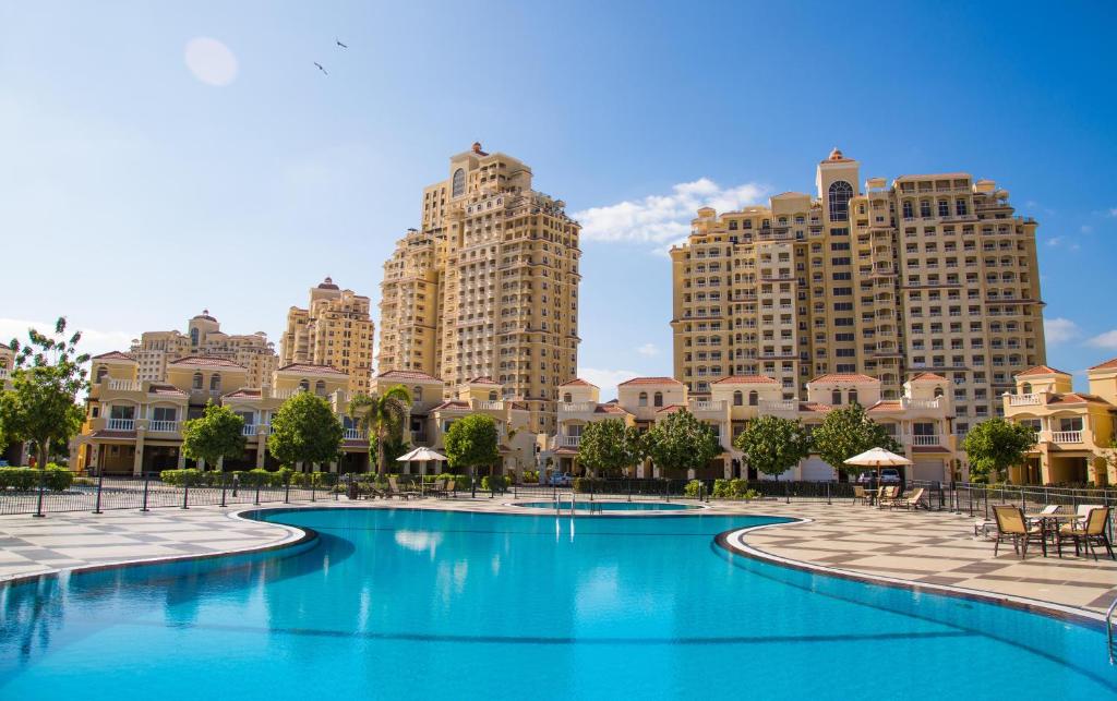 拉斯阿尔卡麦Hala Holiday Homes - Al Hamra Village, RAK的一座游泳池,位于一些高楼前