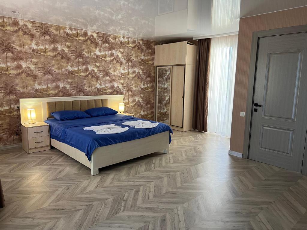第比利斯villa with beautiful view 3的一间卧室设有蓝色的床,铺有木地板。