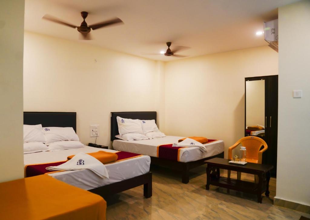 蒂鲁帕蒂Hotel Sitar Grand的酒店客房配有两张床和吊扇。