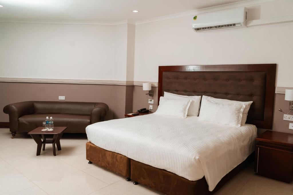 MasvingoGreat Zimbabwe Hotel的一间卧室配有一张床、一把椅子和一张桌子