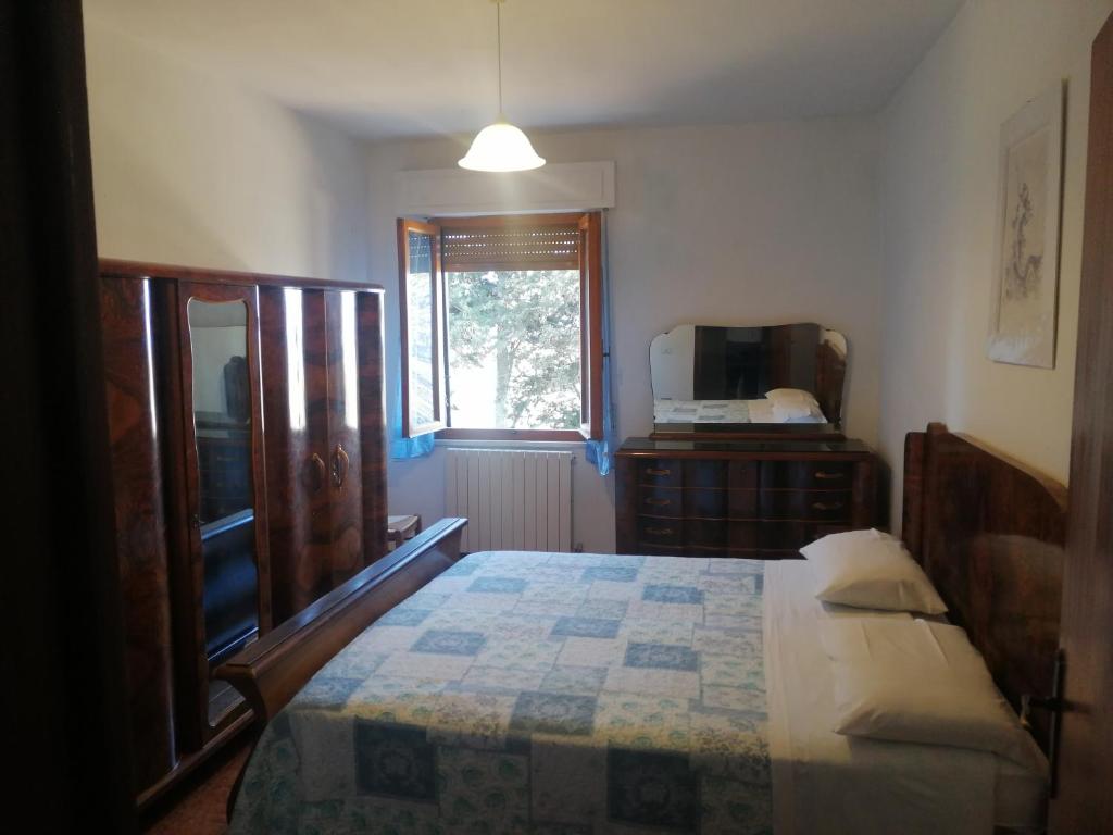 波马兰切Agriturismo Santa Chiara的一间卧室配有一张床、一个梳妆台和一扇窗户。