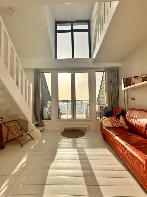 勒克罗图瓦Le Crotoy - Entre ciel et mer的带沙发和大窗户的客厅