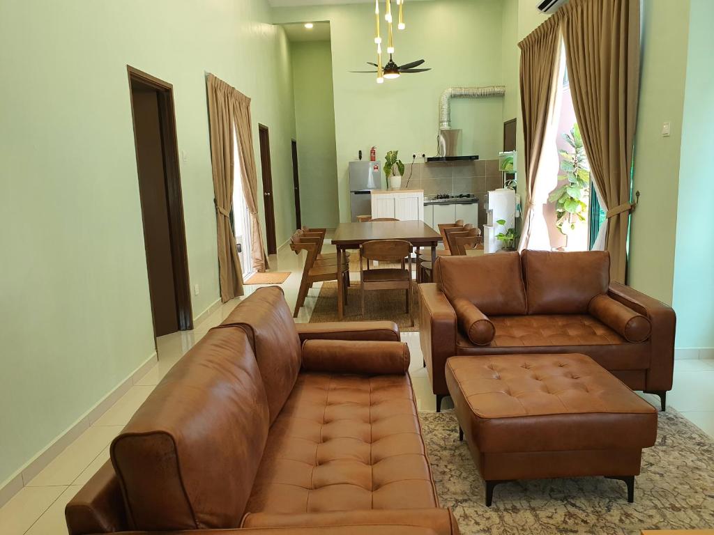 马六甲Duyong Damai Homestay by KOWBMAS的客厅配有沙发、椅子和桌子