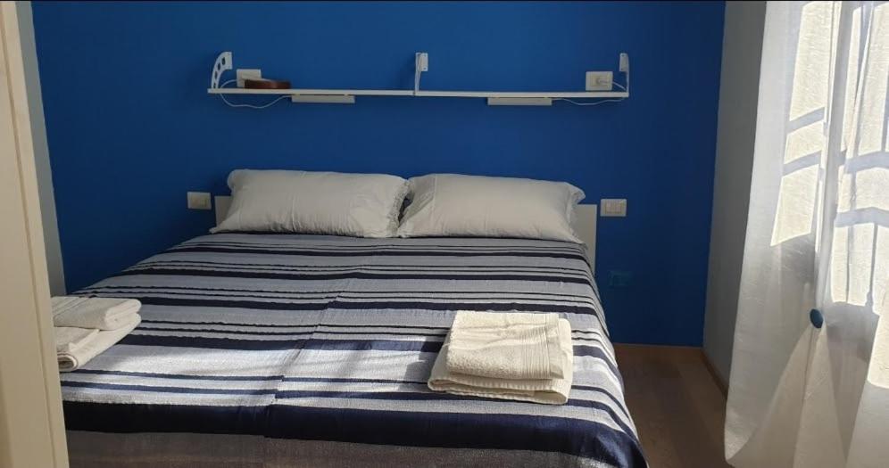 罗镇Monteceneri 9 B&b的蓝色卧室,配有带2条毛巾的床