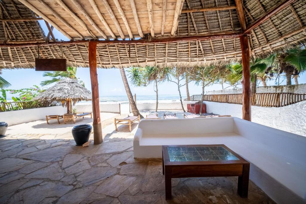 吉汶瓦Beachfront Villa Hideaway ZanzibarHouses的带沙发的客厅,享有海滩美景