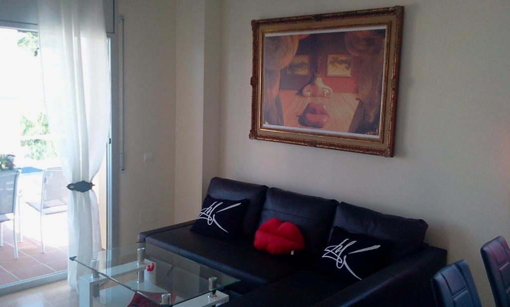 兰卡Dalí Apartment的客厅配有黑色沙发和图片