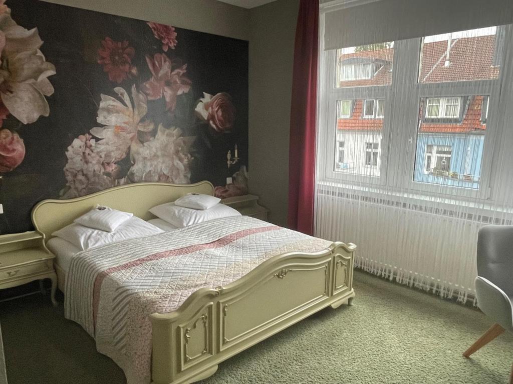 汉诺威豪斯马滕斯酒店的一间卧室配有一张带花卉壁纸的床