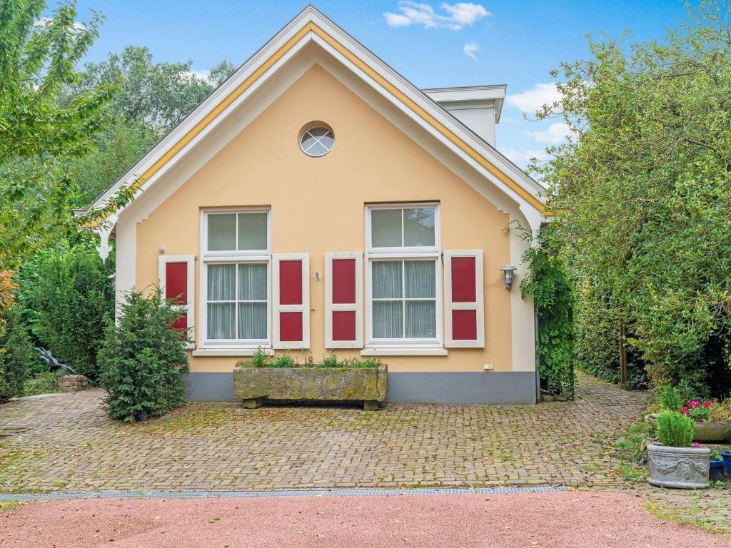 奥尔登扎尔Picturesque Holiday Home in Oldenzaal with Jacuzzi的上面有红色百叶窗的房子
