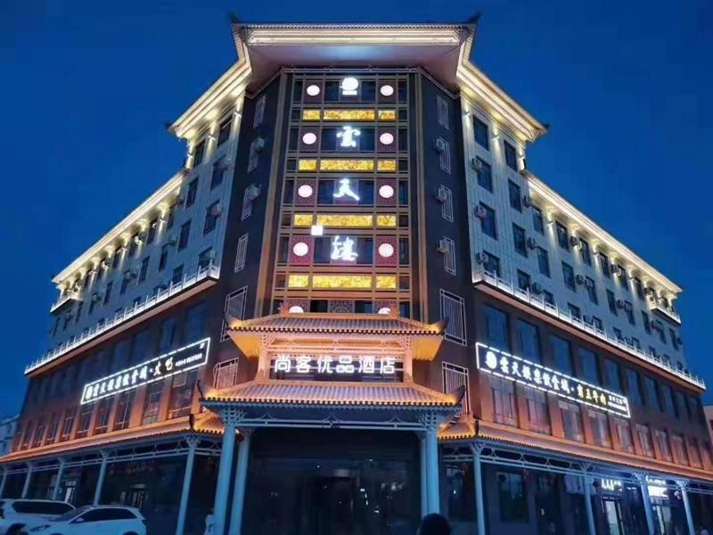 喀什尚客优品喀什疏勒四十一团草湖镇酒店的一座高大的建筑,旁边灯火通明