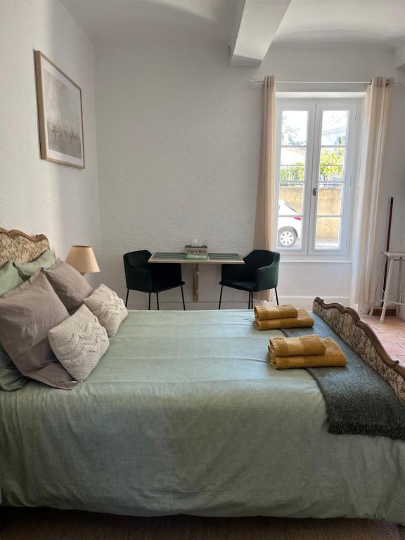 格里尼昂Au Petit Faubourg的一间卧室配有一张带桌椅的床