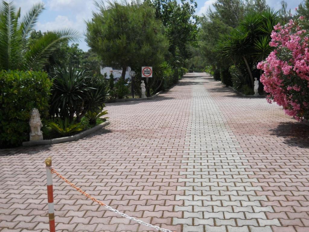 维耶斯泰Case Vacanze Fusillo Rosina的一条红砖路,有树木和粉红色的花