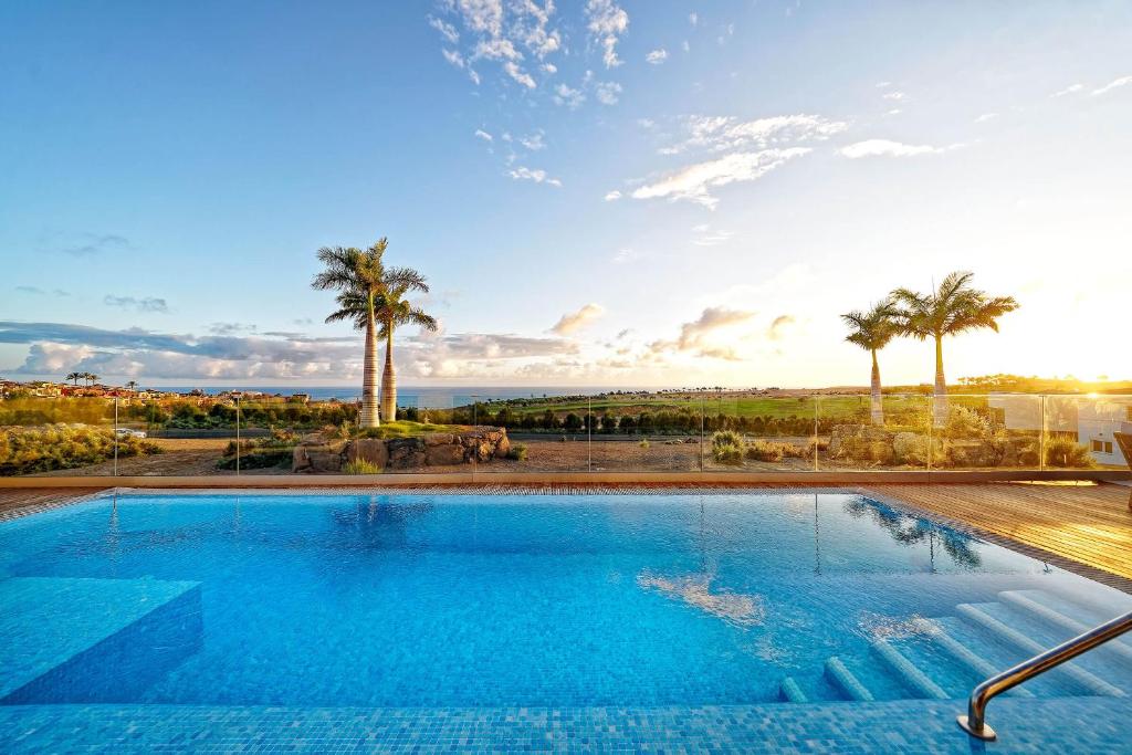 梅罗那瑞斯Ananda Vistas Meloneras by Maspalomas Holiday Villas的享有大海和棕榈树景致的游泳池