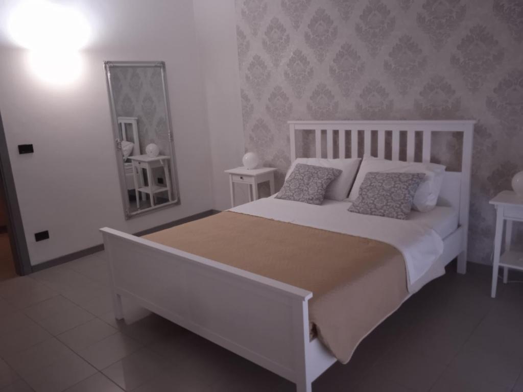 维罗纳Residenza Locatelli的卧室配有白色的床和镜子