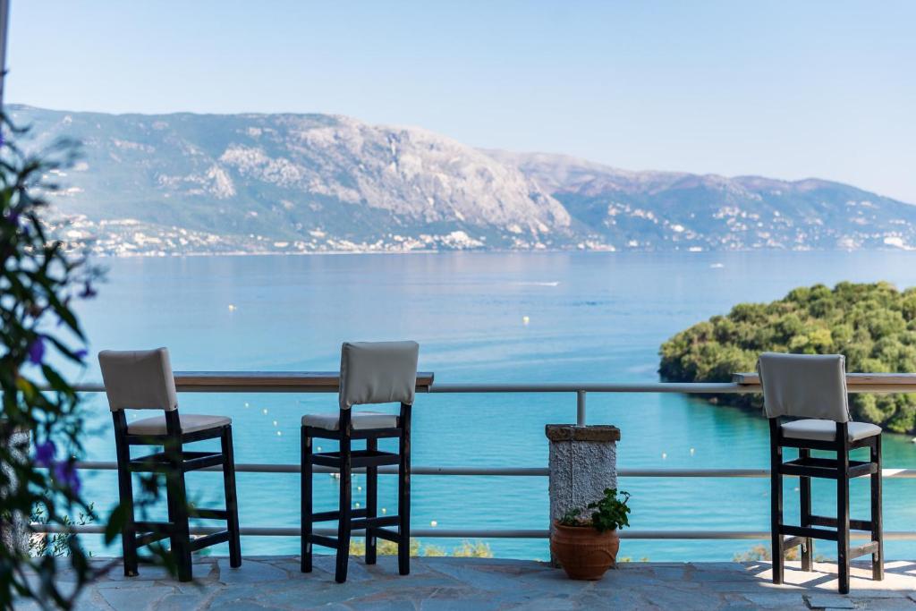 科梅诺Angelos Seaview Studios by Konnect, Kommeno Corfu的一组椅子坐在一个俯瞰湖泊的阳台