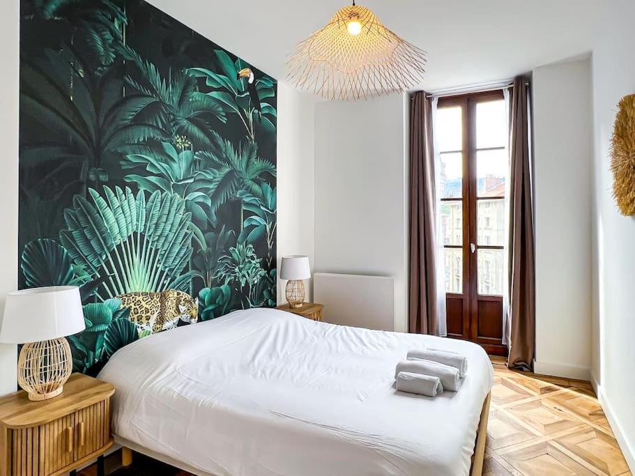 格勒诺布尔Hyper-centre de Grenoble, ambiance tropicale, wifi fibre的一间卧室配有一张带热带壁纸的大床