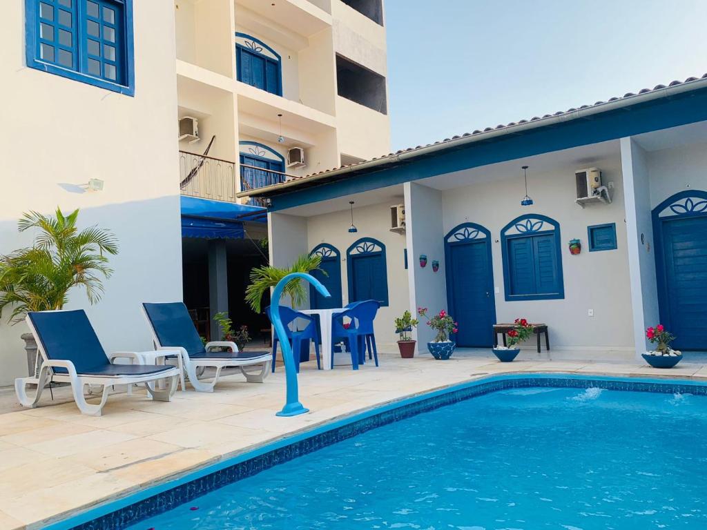 巴雷里尼亚斯Pousada Vila de Charme的一个带游泳池和蓝色门的别墅