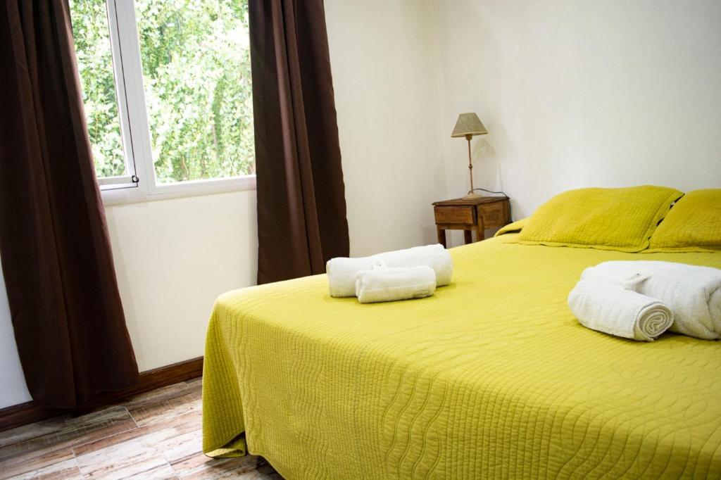 埃尔卡拉法特Bahia Rooms的一间卧室配有黄色的床和毛巾