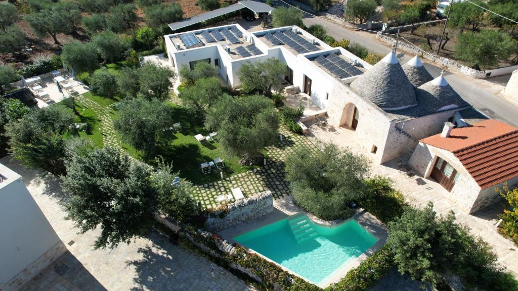 阿尔贝罗贝洛Rifugio di Puglia - Trulli & Dimore的享有带游泳池的房屋的空中景致