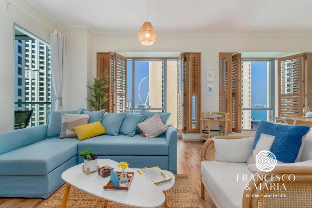 迪拜Boutique Apartment Sea Views - Dubai Marina的客厅配有蓝色的沙发和桌子