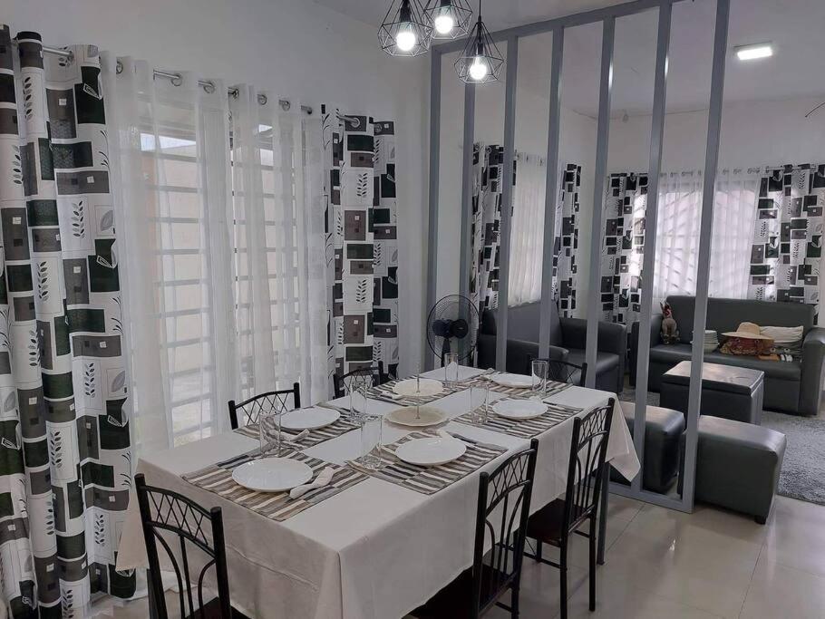 桑托斯将军城FOMAG House GenSan 2BR的一间配备有白色桌椅的用餐室
