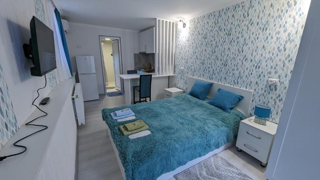 姆茨赫塔White Orchid的一间设有蓝色床和厨房的小卧室