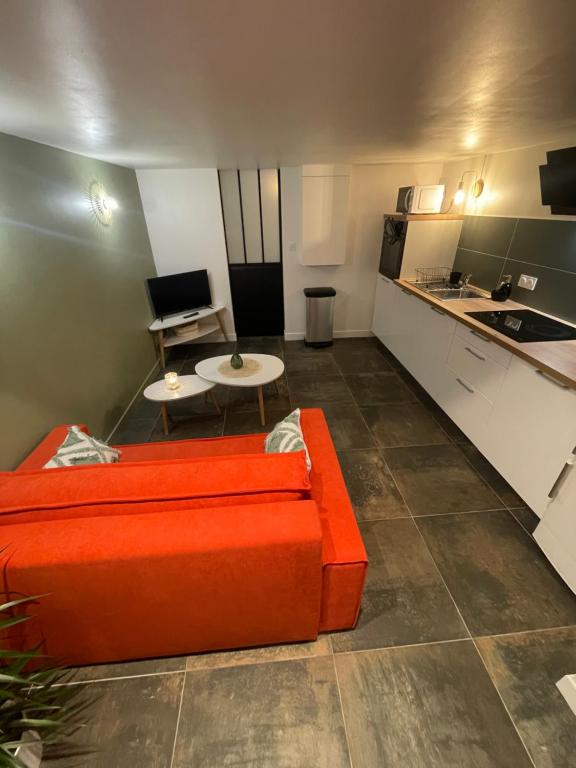 圣布里厄Gare australe的一间带橙色沙发的客厅和一间厨房